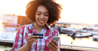 Woman using her card to purchase something on her phone.